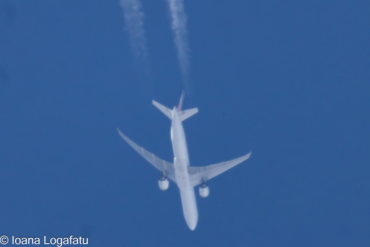 High above the clouds, an airplane journeys on